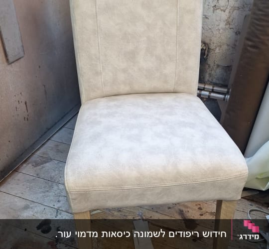 כיסא מרופד בצבע בהיר על רצפת עץ בסדנה